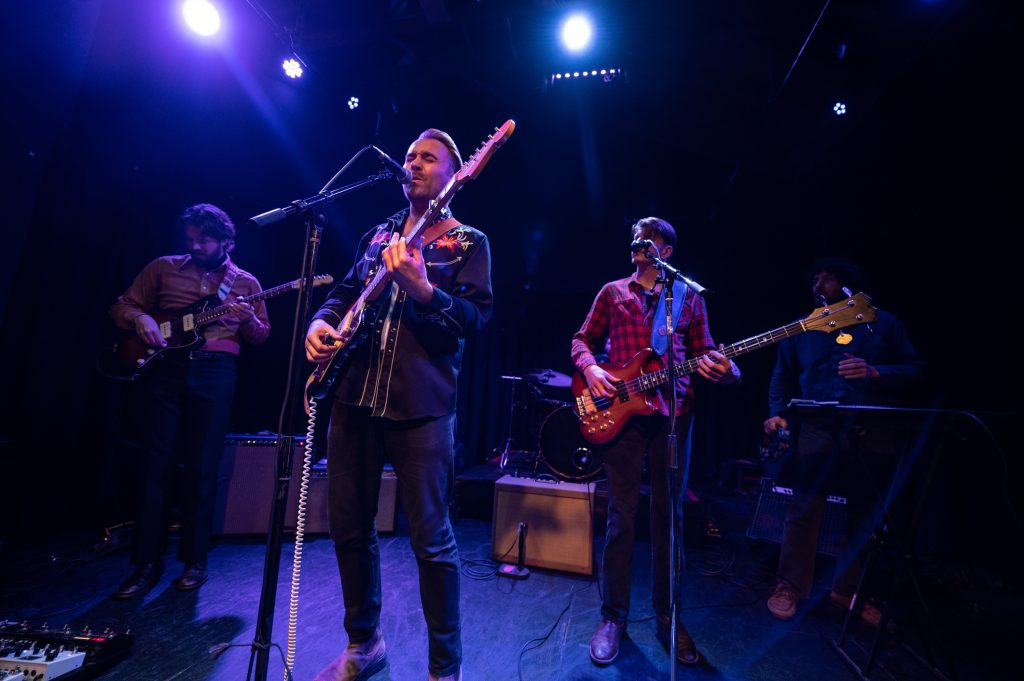 Singer Closing his Eyes While Performing Onstage with Band